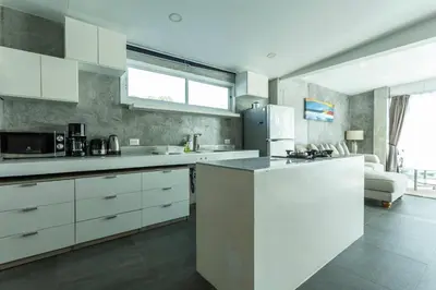 a kitchen with white cabinets and a counter top at 4 Big Separate Apartments SeaView 8KingBeds v104 in Karon Beach