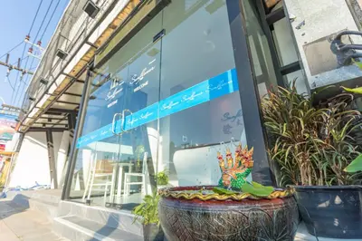 a store window with a large planter in front of it at sun flower \u4e00\u5367\u7cbe\u54c1\u5927\u5e8a\u623f in Patong Beach