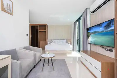a living room with a couch and a bed and a tv at Beach, Relax & Fun! VV Patong 2BR Apartment C201 just 5 min drive from Patong Nightlife in Patong Beach