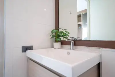 a bathroom with a white sink and a mirror at Beach, Relax & Fun! VV Patong 2BR Apartment C201 just 5 min drive from Patong Nightlife in Patong Beach