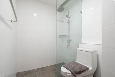 a bathroom with a toilet and a glass shower at Beach, Relax & Fun! VV Patong 2BR Apartment C201 just 5 min drive from Patong Nightlife in Patong Beach