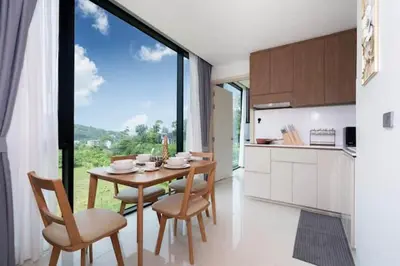 a kitchen and dining room with a table and chairs at Beach, Relax & Fun! VV Patong 2BR Apartment C201 just 5 min drive from Patong Nightlife in Patong Beach