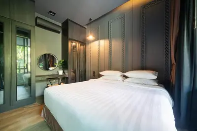 a bedroom with a large bed with white sheets at Saturdays by Lotus Heart in Ban Saiyuan (1)
