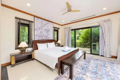 a bedroom with a bed and a desk and windows at Meraya Villa with Private Pool Near Nai Harn Beach in Rawai Beach