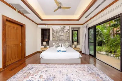 a bedroom with a bed and a large window at Meraya Villa with Private Pool Near Nai Harn Beach in Rawai Beach