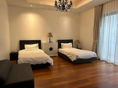 a bedroom with two beds and a couch and a chandelier at A lovely 2-3 bed only 300m walk to Bangtao Beach in Phuket