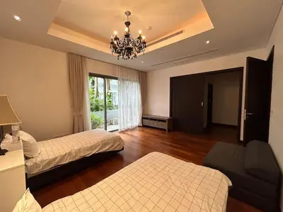 a hotel room with two beds and a chandelier at A lovely 2-3 bed only 300m walk to Bangtao Beach in Phuket