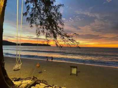 a swing on the beach with the sunset in the background at A lovely 2-3 bed only 300m walk to Bangtao Beach in Phuket