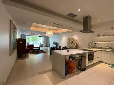 a kitchen and living room with a island in the middle at A lovely 2-3 bed only 300m walk to Bangtao Beach in Phuket