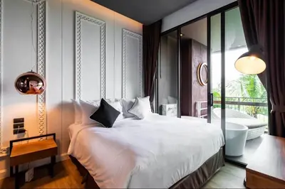 a bedroom with a large white bed and a balcony at Saturdays Residence 1 bedroom Rawai in Ban Saiyuan (1)