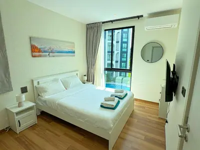 a bedroom with a bed and a large window at The Title Halo1 2BD by MILL in Phuket