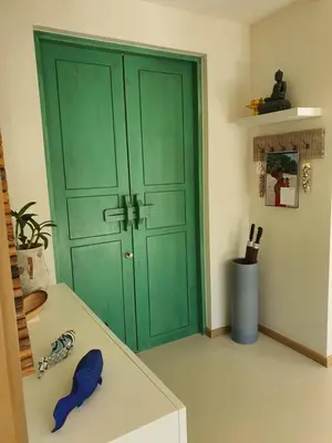 a green door in a room with a table at Luxury 3 bedroom pool villa in Laguna Phuket