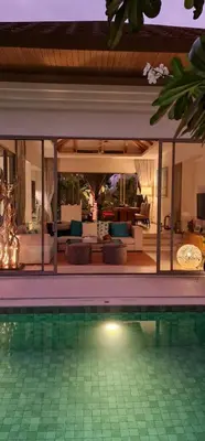 a house with a swimming pool and a living room at Luxury 3 bedroom pool villa in Laguna Phuket