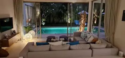a living room with a couch and a pool at Luxury 3 bedroom pool villa in Laguna Phuket