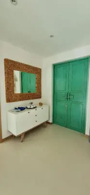 a room with green doors and a table and a mirror at Luxury 3 bedroom pool villa in Laguna Phuket