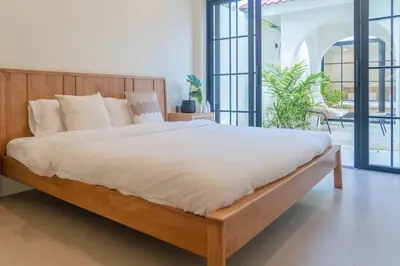 a bedroom with a large bed with white sheets at Villa Cabana in Ban Saiyuan (1)