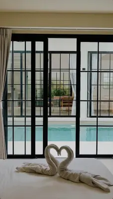 two swans forming a heart on a bed in front of a pool at Villa Cabana in Ban Saiyuan (1)