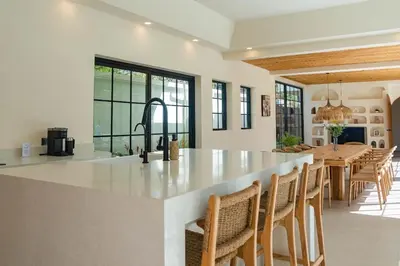 a kitchen and dining room with a large island with chairs at Villa Cabana in Ban Saiyuan (1)