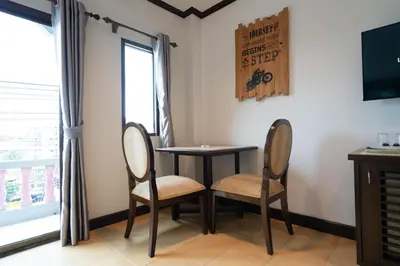a dining room with two chairs and a table and a tv at Tri's Miracle Apartment Kata in Kata Beach