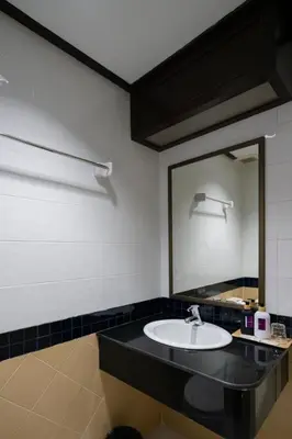 a bathroom with a sink and a mirror at Tri's Miracle Apartment Kata in Kata Beach