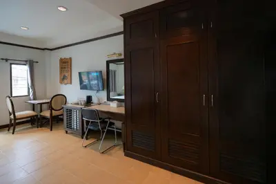 a room with a desk and a cupboard at Tri's Miracle Apartment Kata in Kata Beach