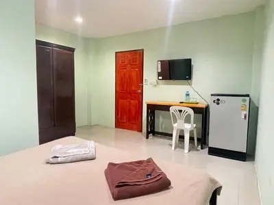 a room with a bed and a kitchen with a refrigerator at SHERRY'S Guest House in Patong Beach