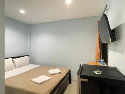 a small room with a bed and a flat screen tv at SHERRY'S Guest House in Patong Beach