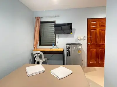 a small room with a table and a desk at SHERRY'S Guest House in Patong Beach
