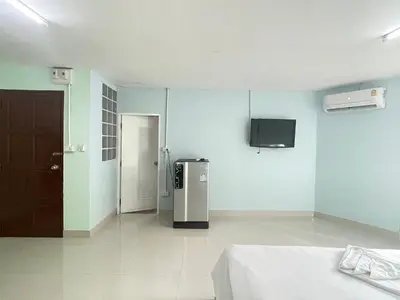 a room with a refrigerator and a tv on the wall at SHERRY'S Guest House in Patong Beach