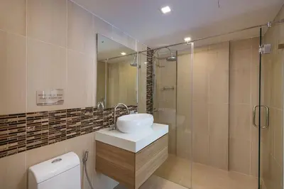 a bathroom with a sink and a glass shower at Calypso condo in Rawai Beach