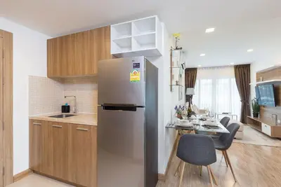 a kitchen with a stainless steel refrigerator and a table at Calypso condo in Rawai Beach