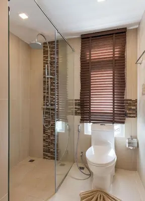 a bathroom with a toilet and a glass shower at Calypso condo in Rawai Beach