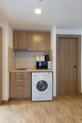 a kitchen with a washing machine in a room at Calypso condo in Rawai Beach
