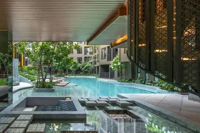 a swimming pool with chairs and a building at The Base Central Phuket-C4YW in Phuket Town