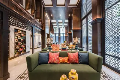 a living room with a green couch with colorful pillows at The Base Central Phuket-C4YW in Phuket Town