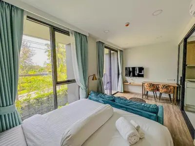 a bedroom with a bed and a large window at Skypark private new apartmant in Phuket