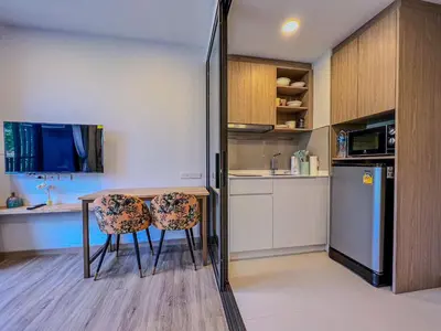 a kitchen with a table and two chairs and a refrigerator at Skypark private new apartmant in Phuket