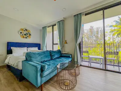 a bedroom with a couch and a bed and a balcony at Skypark private new apartmant in Phuket