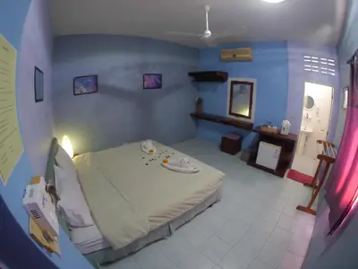 a bedroom with a bed in a blue room at Adams house in Patong Beach