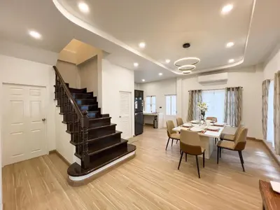 a dining room with a staircase and a table with chairs at 4BR Patong Pool Villa, Sleeps 8 in Patong Beach