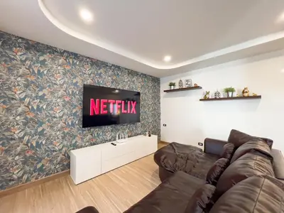 a living room with a couch and a tv on a wall at 4BR Patong Pool Villa, Sleeps 8 in Patong Beach