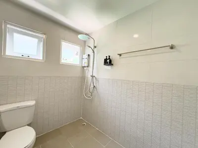 a bathroom with a shower with a toilet and a window at 4BR Patong Pool Villa, Sleeps 8 in Patong Beach