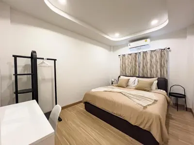 a bedroom with a bed and a table in it at 4BR Patong Pool Villa, Sleeps 8 in Patong Beach