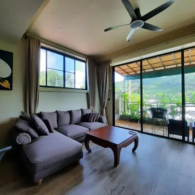 a living room with a couch and a ceiling fan at Naiharn high view villa in Rawai Beach