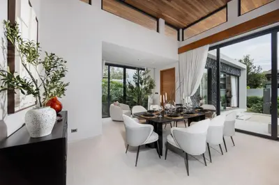 a dining room with a black table and white chairs at Luxury 3BR Villa Eden with Private Pool in Bang Tao Beach