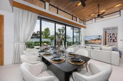 a dining room with a table and white chairs at Luxury 3BR Villa Eden with Private Pool in Bang Tao Beach