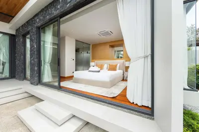 a bedroom in a house with a bed and windows at Luxury 3BR Villa Eden with Private Pool in Bang Tao Beach