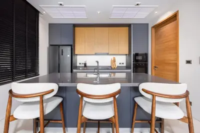a kitchen with a large island with white bar stools at Luxury 3BR Villa Eden with Private Pool in Bang Tao Beach