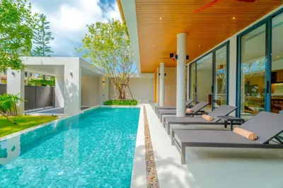 an infinity pool with lounge chairs next to a house at Sava Villa near Rawai in Ban Saiyuan (1)