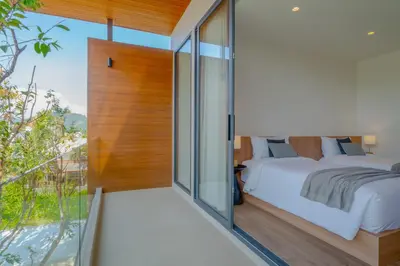 a bedroom with a bed and a large window at Sava Villa near Rawai in Ban Saiyuan (1)